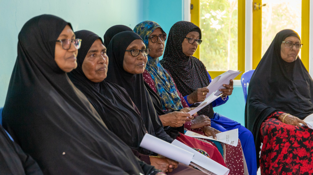 A group of women listen attentively.