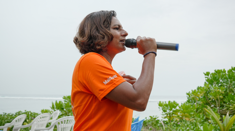 Mayan, President of the Women's Football Club speaking into the mic.