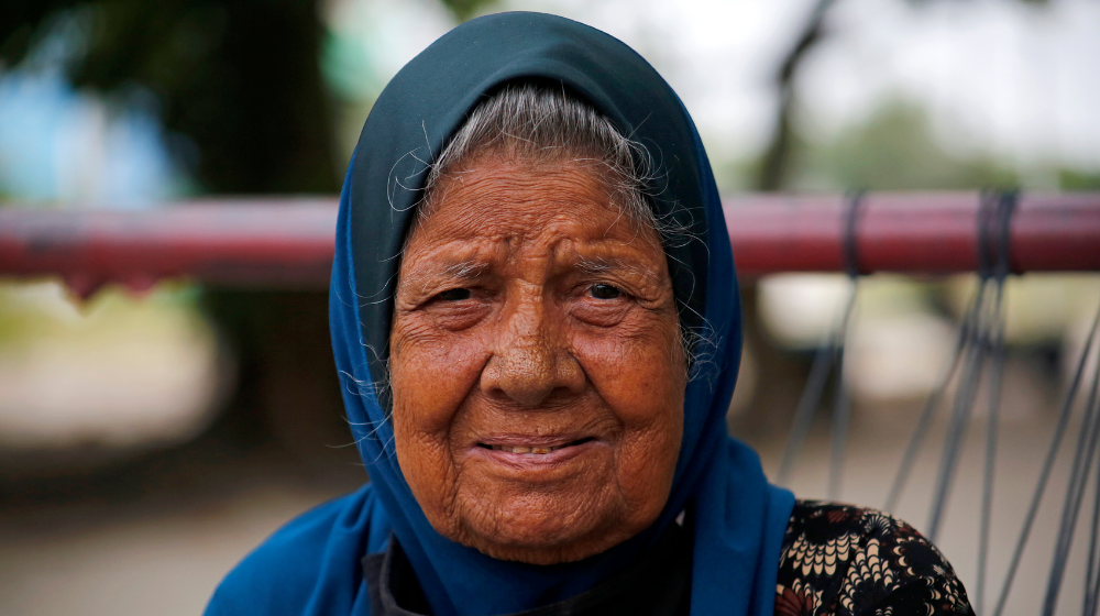 An elderly lady smiles to the camera.