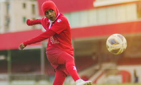 An action shot of Shaliya kicking the football.