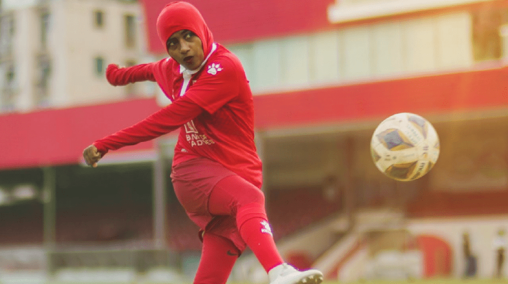 An action shot of Shaliya kicking the football.